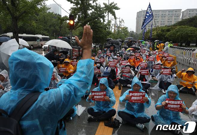 전국금속노조 소속 조합원들이 13일 오후 서울 여의도 산업은행 앞에서 가진 대우조선 하청노동자 총파업 투쟁승리 결의대회에서 구호를 외치고 있다. 이들은 대우조선 하청노동자들이 줄어든 임금 30% 돌려달라며 파업에 돌입한지 40일이 지났지만 문제가 해결되지 않고 있다며 정부와 산업은행이 전면에 나설 것을 촉구했다. 2022.7.13/뉴스1 © News1 신웅수 기자