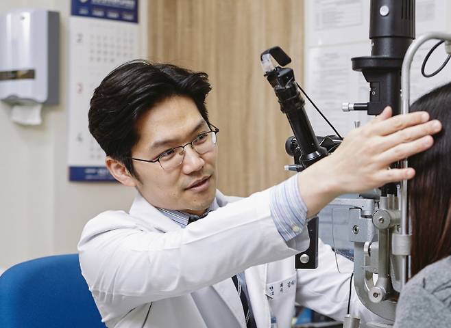 강동경희대병원 안과 김태기 교수가 여름철 광각막염이 의심되는 환자를 검사하고 있다.