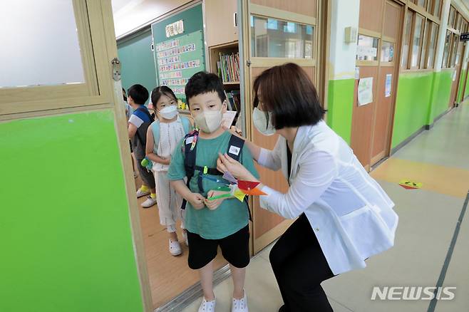 [서울=뉴시스] 조성우 기자 = 지난 15일 오후 서울 중구 청구초등학교에서 선생님이 방학식을 마친 학생들에게 코로나19 예방을 당부하며 하교를 돕고 있다. (공동취재사진) 2022.07.15. photo@newsis.com