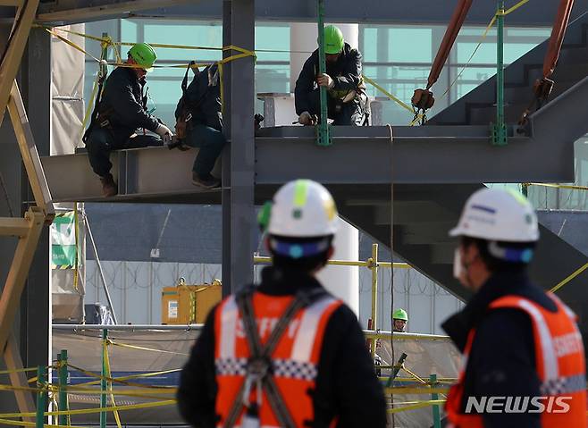 [인천공항=뉴시스] 조성우 기자 = 지난 1월26일 오후 인천국제공항 제2터미널 4단계 건설사업 현장에서 근로자들이 작업을 하고 있다. 2022.01.26. xconfind@newsis.com