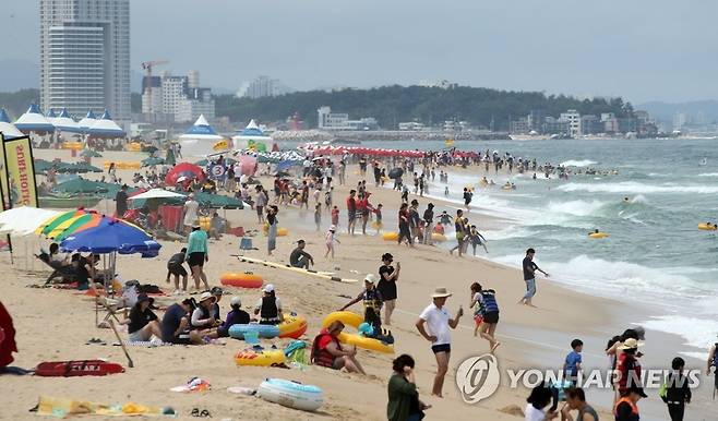 경포해변의 피서객 (강릉=연합뉴스) 유형재 기자 = 17일 강원 강릉시 경포해수욕장에서 높은 파도가 이는 가운데 많은 피서객이 무더위를 식히고 있다. 2022.7.17 yoo21@yna.co.kr