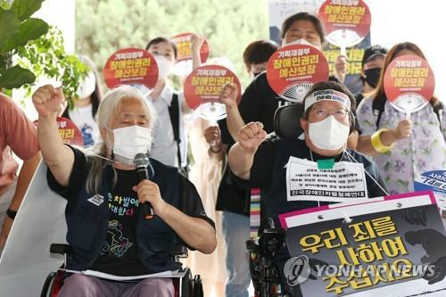 구호 외치는 전장연     (서울=연합뉴스) 신현우 기자 = 전국장애인차별철폐연대(전장연) 회원들이 19일 오전 서울 용산경찰서에서 열린 전장연 경찰 조사 자진출석·김광호 서울경찰청장 법 준수 촉구 기자회견에서 구호를 외치고 있다.
    박경석 전장연 상임대표는 이날 용산경찰서에 승강기가 없다며 경찰 조사를 거부하고 입장문을 전달했다. 2022.7.19
    nowwego@yna.co.kr