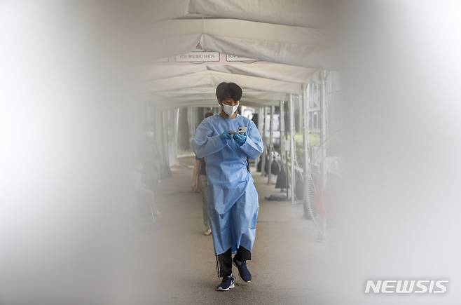 [서울=뉴시스] 정병혁 기자 =  0시 기준 국내 코로나19 신규확진자가 7만6402명으로 집계된 20일 오전 서울 강동구보건소 선별진료소에서 의료진이 코로나19 검사 안내를 하고 있다. 2022.07.20. jhope@newsis.com