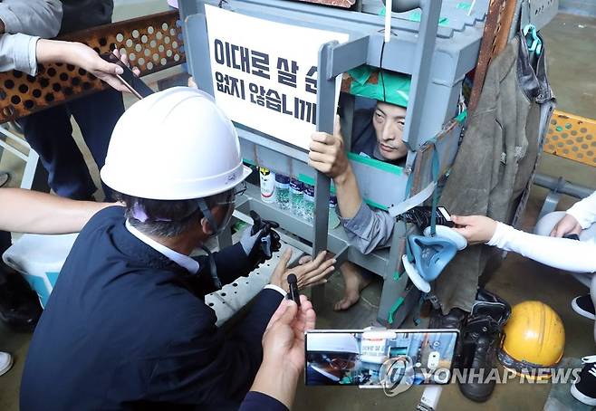 대우조선해양 파업 현장 찾은 이정식 장관 (거제=연합뉴스) 김동민 기자 = 이정식 고용노동부 장관이 19일 오후 경남 거제시 아주동 대우조선해양 옥포조선소 파업 현장을 방문해 조선소 독 화물창 바닥에 가로, 세로, 높이 각 1ｍ 철 구조물 안에서 농성 중인 유최안 금속노조 거제통영고성 조선하청지회 부지회장과 면담하고 있다. 2022.7.19 image@yna.co.kr