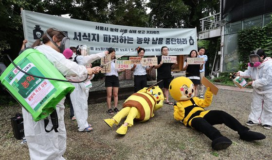 서울환경운동연합 활동가들이 21일 서울 종로구 필운대로 환경센터 앞 마당에서 서울시 공원·가로수·궁궐 일대 고독성 농약 남용 실태와 관련해 보고서 발표 기자회견을 하며 상징의식을 펼치고 있다. 연합뉴스