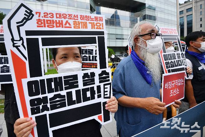 지난 19일 서울 여의도 산업은행 앞에서 열린 7.23 대우조선 하청노동자 희망버스 세부계획 발표 기자회견에서 참석자들이 피켓을 들고 있다. 류영주 기자