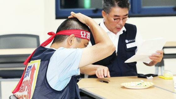 대우조선해양 하청 파업 50일째인 21일 오후 경남 거제시 대우조선해양 옥포조선소에서 홍지욱 금속노조 부위원장(오른쪽)과 이김춘택 조선하청지회 사무장이 협력사 대표 등과 협상을 진행하던 중 회의가 정회되자 머리를 만지고 있다. 연합뉴스