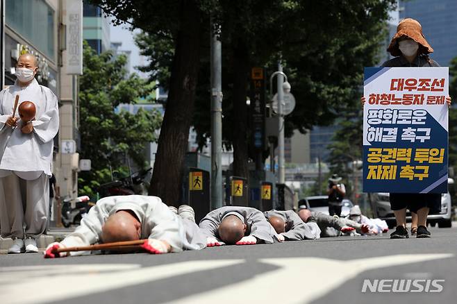 [서울=뉴시스] 백동현 기자 = 조계종사노위 회원들이 22일 오전 서울 중구 서울역 14번출구 앞에서 대우조선 하청노동자 문제의 평화로운 해결과 공권력 투입 자제를 촉구하는 오체투지 퍼포먼스를 하고 있다. 2022.07.22. livertrent@newsis.com