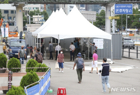 지난 21일 오후 서울역 앞에 관계자들이 코로나19 임시선별검사소를 설치하고 있다. 뉴시스