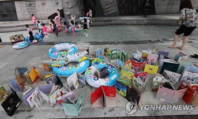 책을 말립니다 (서울=연합뉴스) 한상균 기자 = 22일 송파구 성내천 물놀이장에서 어린이들이 본 책을 말리고 있다. 송파구청은 이날부터 24일까지 성내천 물놀이장 작은도서관을 운영한다. 무료대여. 2022.7.22 xyz@yna.co.kr