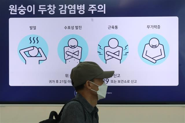 - 5일 인천국제공항 제1여객터미널 출국장 전광판에 표시된 원숭이두창 감염병 주의 안내문 앞을 한 시민이 지나가고 있다.  뉴스1