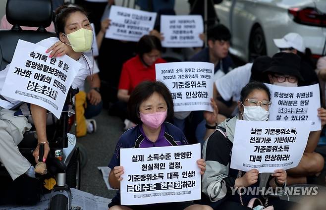 기준중위소득 대폭 인상 촉구 (세종=연합뉴스) 홍해인 기자 = 기초생활보장법 바로 세우기 공동행동, 장애인과 가난한사람들의 3대 적폐 폐지 공동행동 등 시민단체 회원들이 25일 오후 정부세종청사 보건복지부 앞에서 이날 열리는 '기준 중위소득'을 결정하는 중앙생활보장위원회를 앞두고 기준중위소득 대폭 인상, 급여 현실화 등을 촉구하며 기자회견을 하고 있다. 2022.7.25 hihong@yna.co.kr