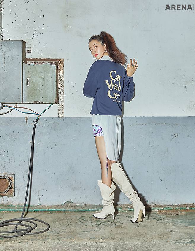 뒷면에 빅 사이즈의 배색 로고로 경쾌함을 더한 스웨트 셔츠는 CRAZY CAR WASH CREW. 이너에 레이어드한 언밸런스한 길이가 매력적인 화이트 셔츠는 STHU. 마블 프린트의 미니 스커트는 ALOL. 이어링과 링, 아이보리 컬러 롱 부츠는 에디터 소장품.
