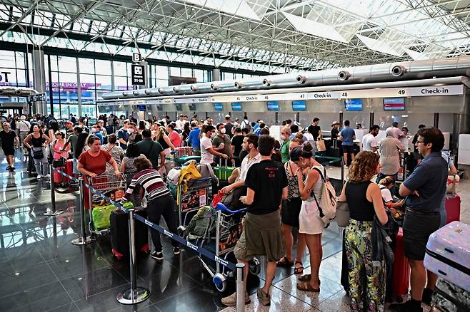 항공사 체크인과 출국·탑승 수속 등에 오랜 시간이 걸리면서 유럽 공항 이용객들 사이에선 출발 6시간 전에 도착해야 한다는 경험담이 확산하고 있다. 사진은 이탈리아 로마공항에서 짐을 부치려는 여행객들. /ⓒAFP=뉴스1