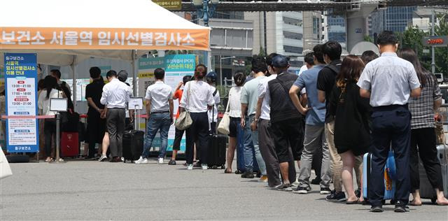 코로나19 신규확진 9만9327명, 석달 만에 다시 10만명 육박 - 26일 서울 중구 서울역 신종 코로나바이러스(코로나19) 임시선별검소에서 시민들이 검사를 위해 길게 줄을 서고 있다. 질병관리청 중앙방역대책본부는 이날 0시 기준 코로나19 신규 확진자가 9만9327명이라고 밝혔다. 1주 전(19일?7만3582명)보다 1.3배 많은 수치다. 지난 4월 이후 세 달만에 다시 10만명에 근접하는 확진자가 나왔다. 신규 사망자는 17명, 위중증 환자는 168명이다. 2022.7.26 뉴스1