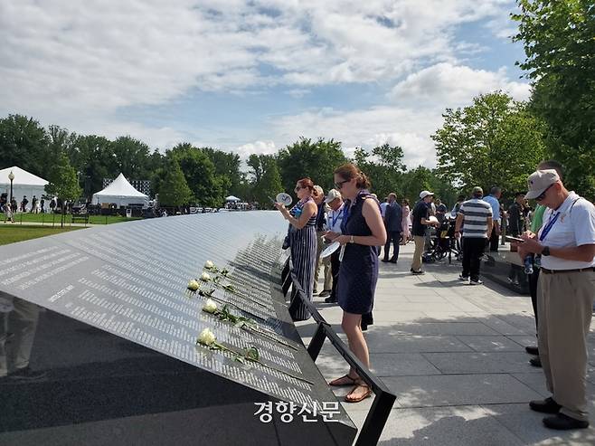 미국과 한국 시민들이 27일(현지시간) 미국 워싱턴에 새롭게 준공된 ‘한국전 전사자 추모의 벽’을 살펴보고 있다. 추모의 벽에는 한국전쟁에서 숨진 미군 전사자 3만6634명과 한국군 카투사 전사자 7174명의 이름이 새겨졌다. 워싱턴|김재중 특파원