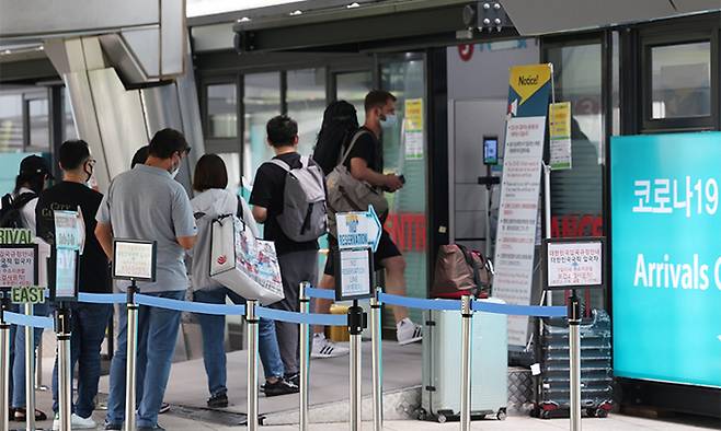 코로나19 해외유입 역대 최다를 기록한 27일 인천국제공항 제1여객터미널 입국자 전용 코로나 검사센터 앞에서 해외 입국자들이 검사를 받기 위해 안내를 받고 있다. 연합뉴스