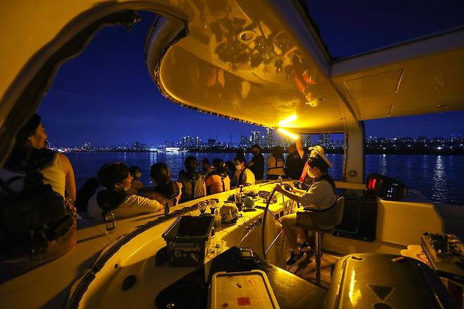 29일 오후 레인보우브릿지 요트페스티벌에 참여한 한 어린이가 요트 선장의 지도 아래 방향 키를 잡아보고 있다. 우상조 기자