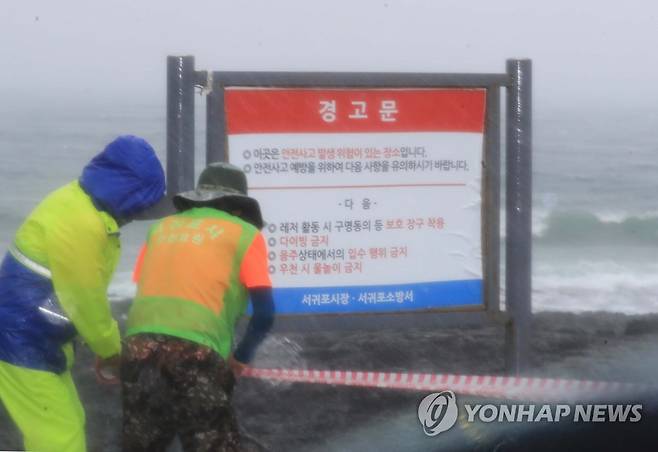 출입 통제된 제주 해안 (서귀포=연합뉴스) 백나용 기자 = 제주도 남쪽 먼바다에 태풍주의보가 발효된 30일 오전 서귀포시청 직원들이 논짓물을 비롯한 주변 해안가 출입을 막는 통제선을 설치하고 있다. 2022.7.30 dragon.me@yna.co.kr