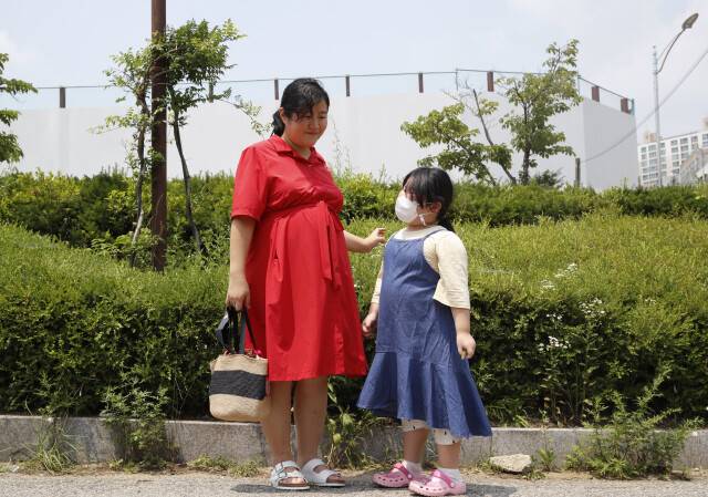 딱따구리(태명)와 최지아 어린이가 엄마 이동현씨와 10일 낮 경기 군포시 대야동에서 산책을 하고 있다. 딱따구리와 지아는 정부가 설정한 ‘온실가스 감축목표’가 충분치 않아 미래세대의 기본권이 침해받고 있다며 정부를 상대로 헌법소원을 제기했다. 군포/김혜윤 기자 unique@hani.co.kr