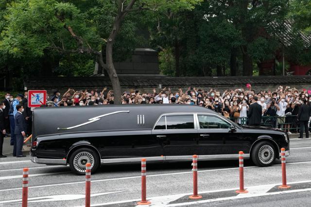 아베 신조 전 일본 총리의 시신 운구 차량이 지난달 12일 일본 도쿄의 조조지에서 장례식을 마친 뒤 사찰을 나서고 있다. 도쿄=AP 뉴시스
