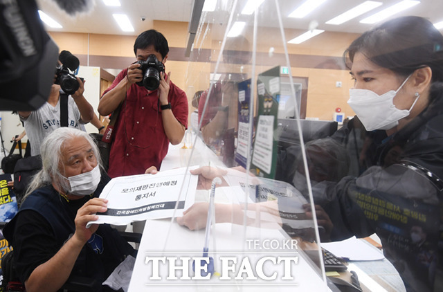 박경석 전국장애인차별철폐연대(전장연) 상임대표(왼쪽)가 2일 오후 서울 종로구 서울경찰청 민원실을 찾아 김광호 서울경찰청의 모의재판 출석요구서를 전달하고 있다. /이새롬 기자