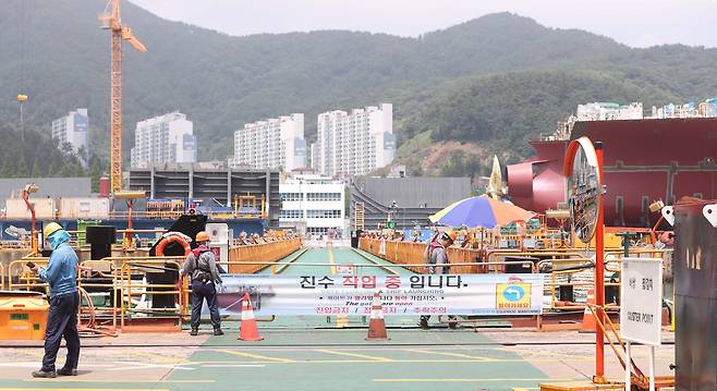 7월 25일 경남 거제시 아주동 대우조선해양 옥포조선소에서 작업자가 진수 작업 현장을 통제하고 있다. 사진 왼쪽이 하청지회 노조가 농성을 벌이던 독이 있던 자리다. 농성했던 선박은 다른 곳으로 이동했다./연합뉴스