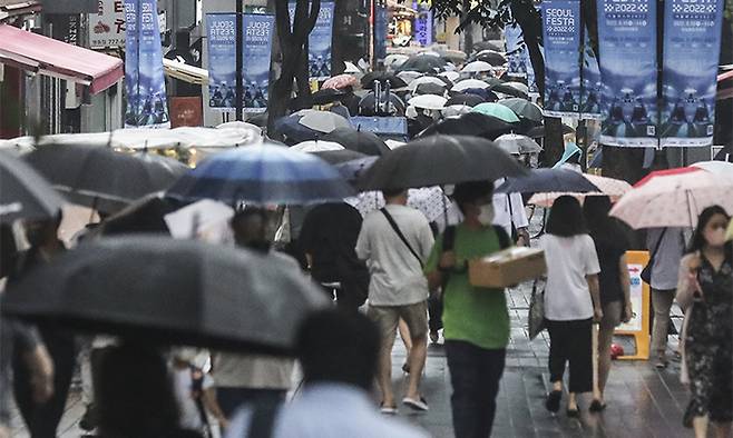 오락가락 비가 내리는 2일 서울 명동거리에서 시민들이 우산을 쓰고 분주하게 이동하고 있다. 뉴시스