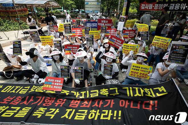 백내장 미지급 보험금 피해자들이 13일 서울 여의도 금융감독원 앞에서 집회를 열고 백내장 미지급 보험금 즉각 지급을 촉구하는 구호를 외치고 있다. 이들은 '노안 백내장' 등으로 안과 전문의에게 진단 및 수술을 받고 보험금을 청구 했으나, 보험회사 측의 '의료자문 동의'에 응해 지급사유에 해당하지 않았다며 보험금 지급이 거절되거나 '의료자문 비동의'를 사유로 보험금 지급을 거부하고 있다고 주장했다. 2022.6.13/뉴스1 ⓒ News1 유승관 기자