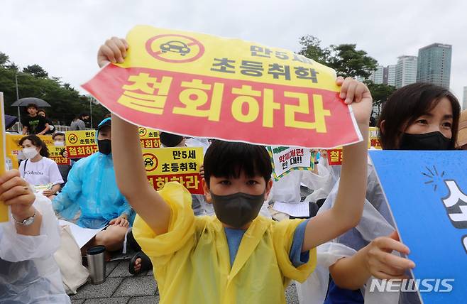 [서울=뉴시스] 이영환 기자 = 지난 2일 오후 서울 용산구 대통령 집무실 인근에서 열린 전국국공립유치원교사노동조합, 교사노동조합연맹 등이 주최한 만5세 조기취학 반대를 위한 총궐기대회에서 한 어린이가 피켓을 들고 있다. 2022.08.03. 20hwan@newsis.com