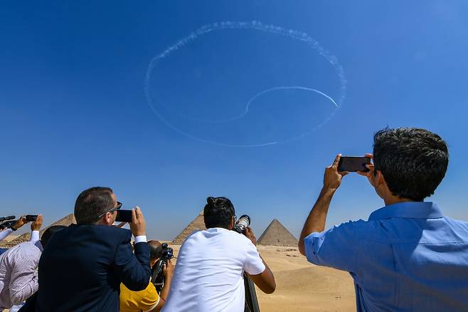 3일 오전(현지시간) 이집트 카이로 인근 기자 대피라미드 주변에서 열린 '피라미드 에어쇼 2022'에를 찾은 관람객 등이 공군 특수비행팀 블랙이글스가 피라미드 상공에 그린 태극 문양을 보며 감탄하고 있다.(공군 제공) 2022.8.4/뉴스1