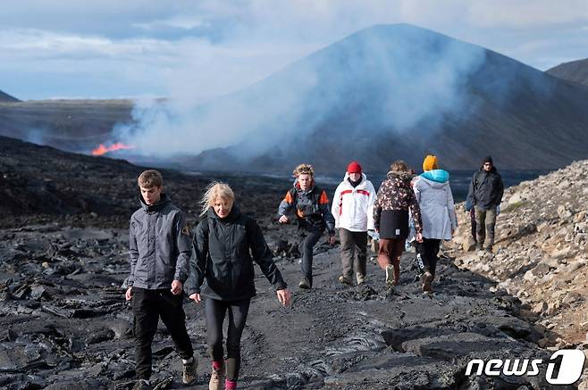 3일(현지시간) 아이슬란드 레이캬네스 반도의 그린다비크에 있는 파그라달스퍄들 화산이 8개월 만에 활동을 재개하는 모습을 주민들이 구경하러 가고 있다. ⓒ AFP=뉴스1 ⓒ News1 우동명 기자