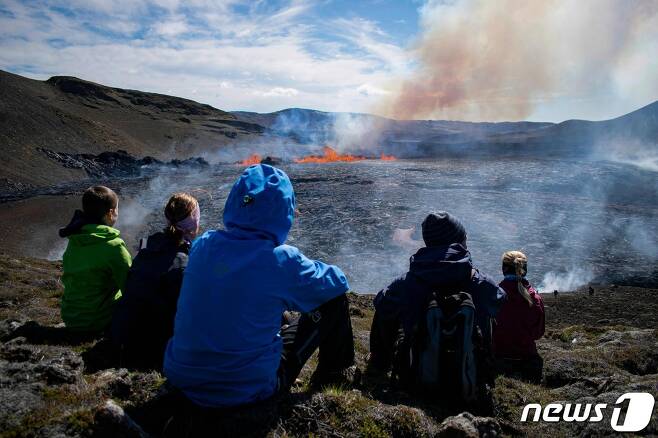 4일(현지시간) 아이슬란드 레이캬네스 반도의 그린다비크에 있는 파그라달스퍄들 화산이 8개월 만에 활동을 재개해 용암을 뿜어내는 모습을 주민들이 구경을 하고 있다. ⓒ AFP=뉴스1 ⓒ News1 우동명 기자