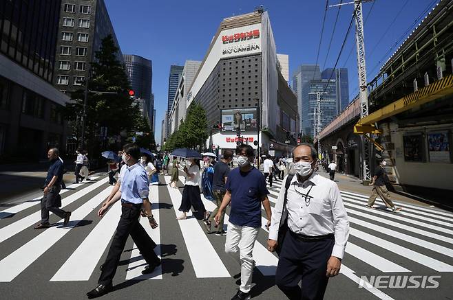 [도쿄=AP/뉴시스] 지난달 29일 일본 도쿄에서 코로나19 확산을 막기 위해 마스크를 쓴 사람들이 건널목을 건너고 있다.