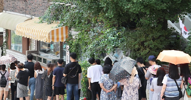 4일 오전 드라마 ‘이상한 변호사 우영우’ 촬영지인 경기도 수원시 팔달구 행궁동의 한 식당에 시민들이 입장을 기다리며 줄을 서 있는 모습. 연합뉴스
