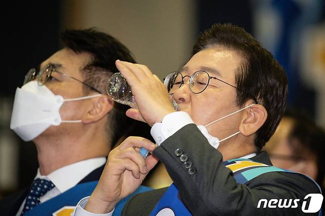 이재명 더불어민주당 당대표 후보가 6일 대구 엑스코에서 열린 민주당 당대표 및 최고위원 후보자 대구·경북지역 합동연설회에서 정견 발표 후 물을 마시 있다. 왼쪽은 박용진 후보. 2022.8.6/뉴스1 ⓒ News1 유승관 기자