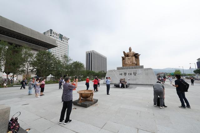 서울 광화문광장이 개장한 6일 오전 시민들이 광장 중심에 있는 세종대왕 동상 앞에서 기념촬영을 하고 있다. 연합뉴스