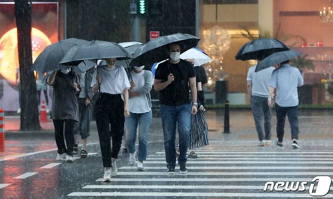 서울을 비롯한 중부지방에 호우특보가 내리며 많은 비가 내리고 있는 8일 서울 강남구 도산대로 횡단보도에서 우산을 쓴 시민들이 발걸음을 재촉하고 있다. 2022.8.8/뉴스1 ⓒ News1 박세연 기자