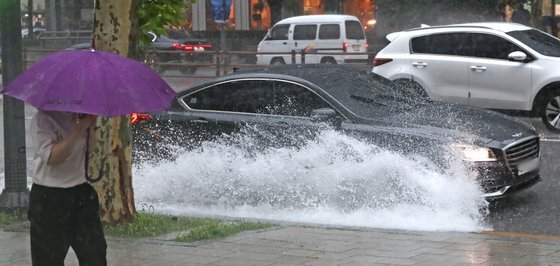 중부지방을 중심으로 폭우가 쏟아진 8일 서울 종로구 종로를 지나는 차량이 물 웅덩이를 지나며 물보라를 일으키고 있다. 뉴스1