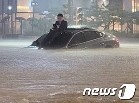 8일 밤 서울의 한 도로가 물에 잠기자 시민이 차체 위로 올라와 있다. (SLR클럽 캡쳐) 2022.8.8/뉴스1 ⓒ News1 이성철 기자