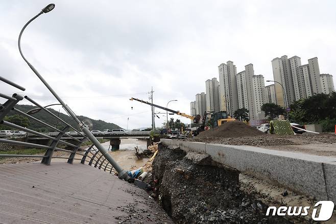 9일 오후 경기 용인시 수지구 동천동 동막천이 범람하면서 도로가 침하되고 도로변에 조성된 데크 길이 무너져 내려 관계자들이 복구작업을 하고 있다. 2022.8.9/뉴스1 ⓒ News1 김영운 기자