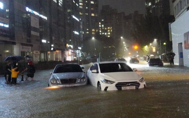 8일 밤 서울 강남구 대치동 은마아파트 부근 도로와 인도가 물에 잠기면서 차량과 보행자가 통행하는 데 불편을 겪고 있다. 사진=연합뉴스