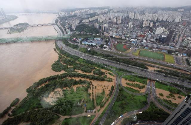 간밤 폭우 등으로 인해 한강 수위가 급격히 상승한 9일 오전 서울 63스퀘어에서 바라본 여의도 한강공원 일대와 통제된 올림픽대로 모습. 연합뉴스.