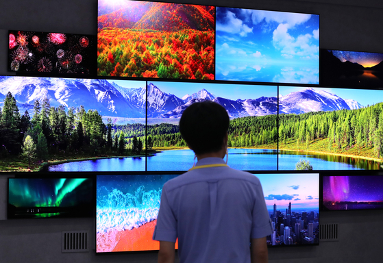 A visitor looks at display screens installed at the K-Display 2022 (Korea Display Exhibition) held at COEX Hall in Gangnam District, southern Seoul, on Wednesday. Companies, including LG Display and Samsung Display, have participated in the exhibition to showcase their display products. The event is hosted by the Korea Display Industry Association and will run through Aug. 12. [NEWS1]