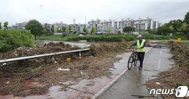 충청권에 폭우가 쏟아지며 대전지역에도 비 피해가 속출하고 있는 가운데 지난 10일 대전 유성천에서 한 시민이 침수로 훼손된 하천보행도를 지나고 있다. 2022.8.10/뉴스1 ⓒ News1 김기태 기자
