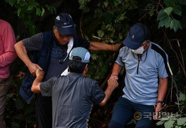 11일 강원도 춘천 소양강댐이 개방한 가운데 시민들이 일행을 비탈길 위로 끌어올리고 있다.