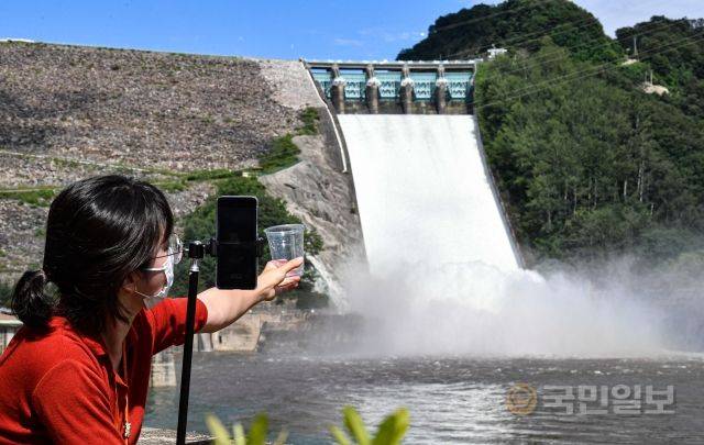 11일 강원도 춘천 소양강댐이 개방한 가운데 강원도청 관계자가 숏폼 콘텐츠를 제작하고 있다.