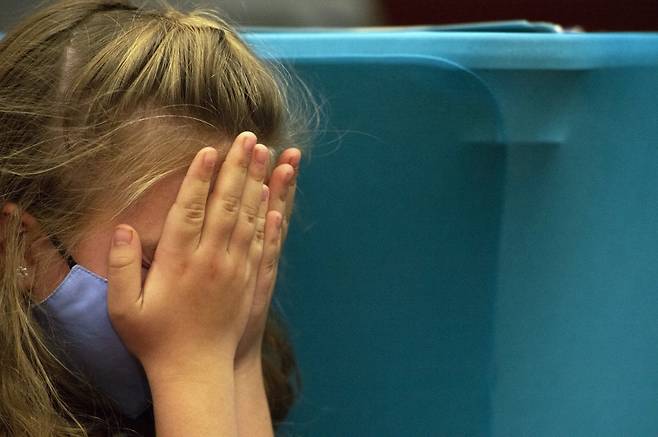 백신 접종을 앞두고 긴장한 어린이가 손으로 얼굴을 가리고 있다. /ⓒAFP=뉴스1