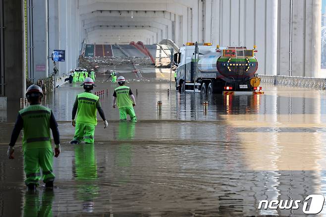 12일 오후 폭우로 인한 한강 수위 상승으로 닷새 동안 양방향이 통제된 서울 잠수교에서 관계자들이 통행 재개를 위한 복구 작업을 하고 있다. 2022.8.12/뉴스1 ⓒ News1 이광호 기자