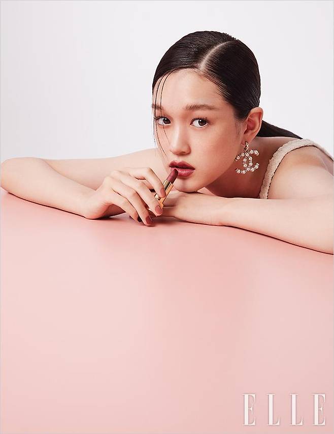 수현의 장밋빛 피부 톤에 어울리는 울트라 르 뗑, BR22로 피부를 매끄럽게 정돈한다. 모브빛이 감도는 피치 베이지 계열의 레 꺄트르 옹브르, 352 엘리멘탈을 눈가에 바르고, 톤다운된 로즈우드빛이 매력적인 루쥬 알뤼르, 198 누앙스를 입술에 발라 마무리. 사용 제품은 모두 Chanel.크로셰 원피스와 이어링은 모두 Chanel.